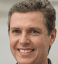 Middle aged man smiling in a relaxed setting reflecting improved daily energy and overall satisfaction with his wellness routine